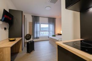 a small apartment with a kitchen and a bed at Jade&Jabo - Moderne möblierte Serviced Apartments - Düsseldorf-Neuss in Neuss