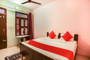 a bedroom with a bed with red pillows at Flagship Park Hotel in Bahora
