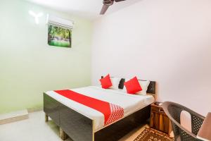 a bedroom with a bed with red pillows at Flagship Park Hotel in Bahora