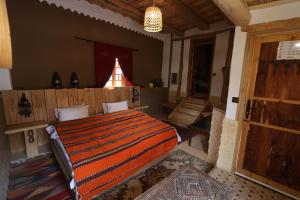 una camera con letto e porta in legno di Dar Jnan Tiouira Dades a Tamellalt