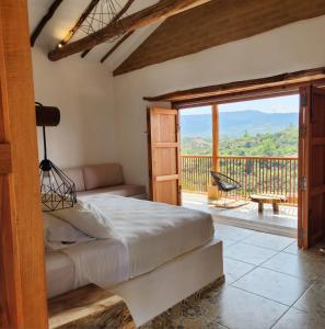 a bedroom with a bed and a balcony with a view at Casa Bocore in Barichara