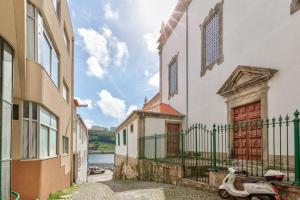 ein Roller, der in einer Gasse zwischen zwei Gebäuden parkt in der Unterkunft Cais das Pedras Duplex by Cozy Stay in Porto