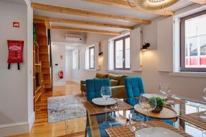 ein Wohnzimmer mit einem Glastisch und blauen Stühlen in der Unterkunft Cais das Pedras Duplex by Cozy Stay in Porto