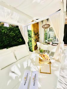Cette chambre blanche dispose d'un canapé et d'une table blancs. dans l'établissement Luxury villa Fanabe with private garden, à Adeje