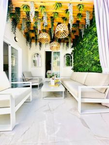 Elle comprend un salon doté d'un mobilier blanc et d'un mur vert. dans l'établissement Luxury villa Fanabe with private garden, à Adeje