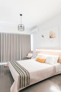 biała sypialnia z łóżkiem i krzesłem w obiekcie MAGNOLIA SUITES w mieście Nafpaktos