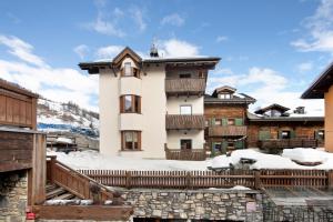 Mountain Apartments Livigno في ليفينو: مبنى كبير مع ثلج على الأرض