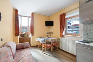 uma sala de estar com uma mesa e um sofá em Mountain Apartments Livigno em Livigno