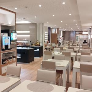 a restaurant with white tables and white chairs at Hotel Windsor in Funchal