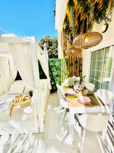 a patio with white furniture and a table and chairs at Luxury villa Fanabe with private garden in Adeje