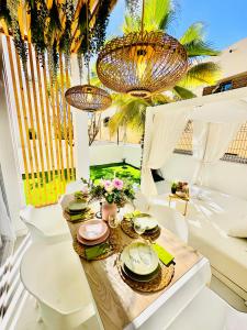 une salle à manger avec des chaises blanches, une table et des lustres dans l'établissement Luxury villa Fanabe with private garden, à Adeje