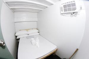 Habitación blanca pequeña con aire acondicionado en Dickem's Transient House en Cebu City