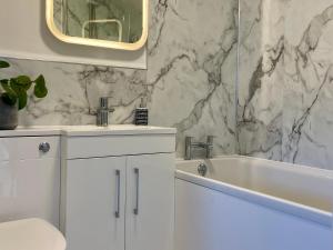 Un baño con dos lavabos, una bañera y un espejo. en Lake Villa Holiday Cottages, en Holsworthy 64 fotos más