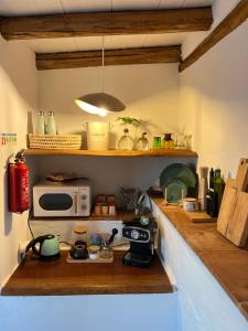 a kitchen with a counter top with a microwave at Casa Estrela in Loulé