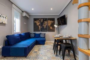 a living room with a blue couch and a table at Dúplex 2 plantas en Madrid Cuzco - Plz Castilla - Home Sweet Home in Madrid