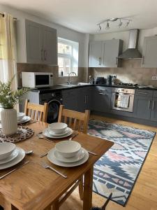 a kitchen with a wooden table with plates on it at Stylish 3 Bed House Hitchin in Hitchin