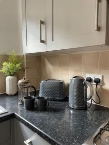 a kitchen counter with pots and pans on a counter top at Stylish 3 Bed House Hitchin in Hitchin