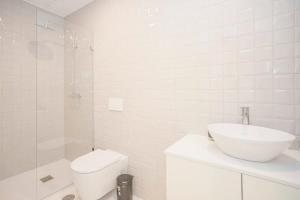 een witte badkamer met een wastafel en een toilet bij Liiiving in Porto - Sweet Sunlight Apartment in Porto