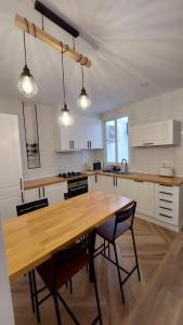 eine Küche mit einem Holztisch mit Stühlen und Lampen in der Unterkunft Lemon Tree Home in Castellón de la Plana