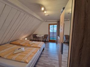 two beds in a room with a table and chairs at Cafe & Pension Carmen in Brotterode-Trusetal