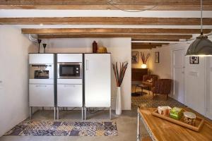 ラ・ガリガにあるEl Til·lerの白い冷蔵庫とテーブルのあるキッチン