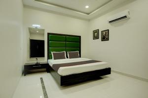 1 dormitorio con 1 cama grande y cabecero verde en Ovel Hotel Grand, en Ābādpura