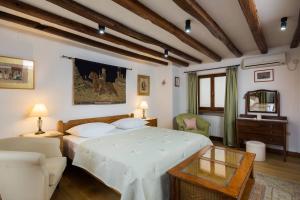 a bedroom with a large white bed and a table at Harbour Holiday Home "Vilmin Dvor" in Murter