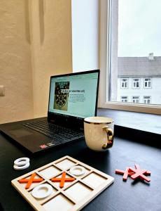 a laptop computer sitting on a desk next to a window at Tiramisu in Ventspils