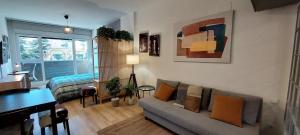 een woonkamer met een bank en een tafel bij Studio Europa 30 in San Sebastián de los Reyes