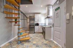 a kitchen with a spiral staircase in a room at Dúplex 2 plantas en Madrid Cuzco - Plz Castilla - Home Sweet Home in Madrid