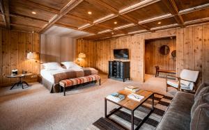a bedroom with a bed and a couch and a table at Hôtel LA MOURRA in Val dʼIsère +38 photos