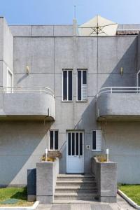 um edifício com uma porta branca e escadas em frente em Charming Beach Retreat by MP na Madalena