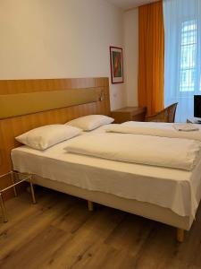 a bedroom with two beds and a television in it at Hotel Post 11 in Braunau am Inn +26 photos
