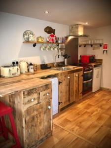 a kitchen with wooden cabinets and a counter top at Unique Private Lodge in Cornwall sleeps 4 