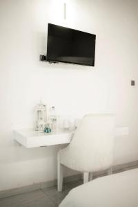 een witte kamer met een stoel en een tv aan de muur bij Sunset Villa in Waskaduwa