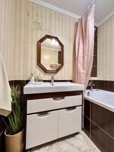 a bathroom with a sink and a tub and a mirror at Подобово квартира Тернопіль Бам 2 кімнати in Ternopilʼ