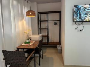 a dining room with a table and a television at La Jungla in Carrillo