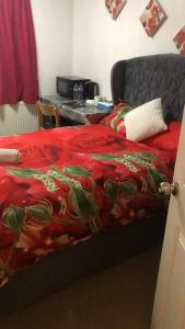 a bed with a red blanket on top of it at 34 Furlong Close Room in a Home in Oxford