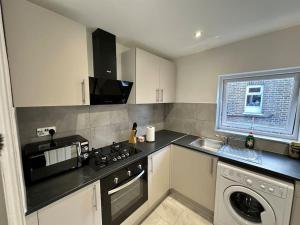 a kitchen with a stove top oven next to a dishwasher at 3 bed Hackney/Harringay Flat in London