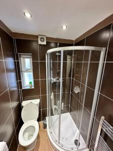 ein Bad mit einem WC und einer Dusche in der Unterkunft 3 bed Hackney/Harringay Flat in London