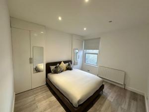 ein Schlafzimmer mit einem großen Bett in einem Zimmer in der Unterkunft 3 bed Hackney/Harringay Flat in London