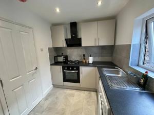 a kitchen with a sink and a stove top oven at 3 bed Hackney/Harringay Flat in London