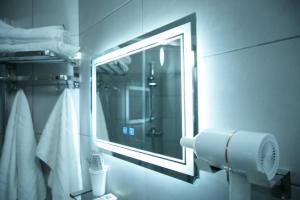 a bathroom with a mirror and a towel at Hôtel du Marché Paris in Paris