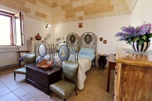 Schlafzimmer mit einem Bett, einem Tisch und Stühlen in der Unterkunft Villa Alida - Con Ampio Giardino E Piscina Privata Nel Salento in Andrano