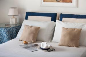 a hat and glasses sitting on a bed with pillows at YourHome - Villa Mia in Massa Lubrense