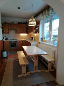 uma cozinha com uma mesa de madeira e dois bancos em Gabriella Ház em Szólád