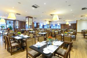 a restaurant with tables and chairs in a room at Windsor Marapendi Hotel in Rio de Janeiro