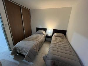 Duas camas estão alinhadas num quarto em Del Camino. Hospedaje Temporal em Zapala