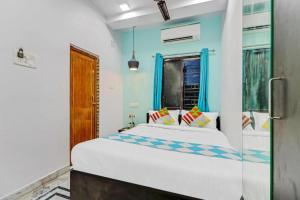 a bedroom with a large white bed with blue walls at Hotel M M Howrah Maidan Home Stay Inn Kolkata in Hāora