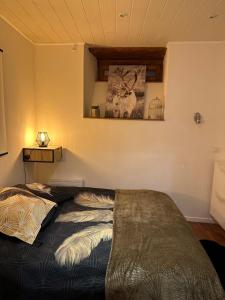 1 dormitorio con 1 cama y una foto en la pared en L 'étape, en Soultz-Haut-Rhin